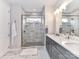 Bright bathroom featuring a double vanity, glass shower with marble tile, and herringbone tile flooring at 5811 Mantle Way, Kannapolis, NC 28081