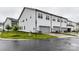 Modern townhouse with a gray garage door and white siding surrounded by a lush green lawn at 5811 Mantle Way, Kannapolis, NC 28081