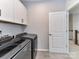 Laundry room features gray washer and dryer with white cabinets for storage, offering a functional space at 5811 Mantle Way, Kannapolis, NC 28081