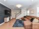 Comfortable living room featuring a large sectional sofa, TV, and staircase at 5811 Mantle Way, Kannapolis, NC 28081