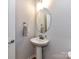 Powder room featuring a pedestal sink, an oval mirror, and modern fixtures at 5811 Mantle Way, Kannapolis, NC 28081