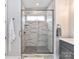 Bright bathroom displaying glass enclosed shower with marbled tile, a window, and herringbone flooring at 5811 Mantle Way, Kannapolis, NC 28081