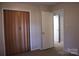 This bedroom includes a folding door closet, neutral paint, and neutral carpet at 606 E 4Th Ave, Gastonia, NC 28054