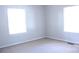 Bright, empty bedroom with two windows and neutral walls and floors at 606 E 4Th Ave, Gastonia, NC 28054