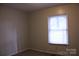 This bedroom has neutral paint, carpet, and a single window at 606 E 4Th Ave, Gastonia, NC 28054