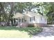 Charming yellow home with a covered front porch and mature trees at 606 E 4Th Ave, Gastonia, NC 28054