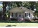 Inviting yellow home with covered porch, dark shutters, and neat landscaping at 606 E 4Th Ave, Gastonia, NC 28054