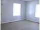 Bright, empty living room with two windows and neutral walls at 606 E 4Th Ave, Gastonia, NC 28054