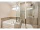 Well-lit bathroom featuring a tub, a walk-in shower, and neutral color scheme at 705 Hinterland Ln, Matthews, NC 28104
