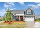 Inviting two-story home with a well-kept lawn, brick accents, and an attached garage at 705 Hinterland Ln, Matthews, NC 28104