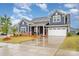 Beautiful two-story home with a manicured lawn, brick accents, and a two-car garage at 705 Hinterland Ln, Matthews, NC 28104