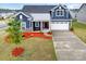Charming home with blue siding, white trim, inviting front porch, and manicured landscaping at 705 Hinterland Ln, Matthews, NC 28104