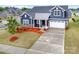 Beautiful home with blue siding, a white garage door, and well-manicured landscaping at 705 Hinterland Ln, Matthews, NC 28104