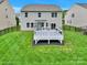 A spacious backyard featuring a well-maintained lawn, a modern deck, and a charming pergola at 7101 Agnew Dr, Charlotte, NC 28273