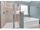 This bathroom features a tiled shower, a soaking tub and a window at 7101 Agnew Dr, Charlotte, NC 28273