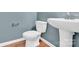 Cozy half bath with classic fixtures, pedestal sink, and tiled flooring in a well-lit setting at 7101 Agnew Dr, Charlotte, NC 28273