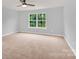 Large bedroom featuring neutral carpet, a ceiling fan, and a double hung window for natural light at 7101 Agnew Dr, Charlotte, NC 28273