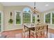 Elegant dining room with a chandelier, large windows, and a table with seating for eight at 7480 Katelyn Ct, Harrisburg, NC 28075