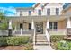 Inviting front porch with stone accents, ceiling fans, and a view of the front yard at 7480 Katelyn Ct, Harrisburg, NC 28075