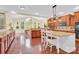 Spacious kitchen boasts hardwood floors, granite countertops, an island with seating, and plenty of natural light at 7480 Katelyn Ct, Harrisburg, NC 28075