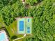 Overhead view of a neighborhood tennis court with basketball hoop, surrounded by lush greenery at 7480 Katelyn Ct, Harrisburg, NC 28075