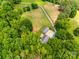 Aerial view of a home nestled amidst lush greenery, featuring a long driveway and expansive outdoor space at 7712 Old Waxhaw Monroe Rd, Waxhaw, NC 28173
