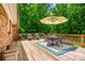 Outdoor deck with a dining table, chairs, and umbrella, perfect for enjoying meals and entertaining in the backyard at 7712 Old Waxhaw Monroe Rd, Waxhaw, NC 28173
