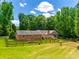 Expansive backyard with a horse in the pasture, featuring a wooden fence and lush greenery, a charming retreat at 7712 Old Waxhaw Monroe Rd, Waxhaw, NC 28173