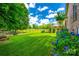 Lush backyard with green grass, beautiful hydrangeas, and trees, offering plenty of space for outdoor activities and relaxation at 7712 Old Waxhaw Monroe Rd, Waxhaw, NC 28173