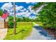 Long gravel driveway leading to a property with green lawns, a fence, trees, and a basketball hoop over the garage at 7712 Old Waxhaw Monroe Rd, Waxhaw, NC 28173