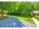 Long gravel driveway leading to a charming brick home surrounded by lush greenery and mature trees at 7712 Old Waxhaw Monroe Rd, Waxhaw, NC 28173