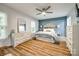 Stylishly decorated bedroom with wood floors, a ceiling fan, and a blue accent wall, creating a cozy and inviting space at 7712 Old Waxhaw Monroe Rd, Waxhaw, NC 28173