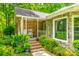Inviting front porch with brick and stone exterior, rocking chair, and lush landscaping at 7712 Old Waxhaw Monroe Rd, Waxhaw, NC 28173