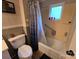 A well-lit bathroom with a shower/tub combo, toilet, and tile accents at 804 Dennis St, Troy, NC 27371