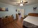 Bedroom with wood flooring, ceiling fan, and ample closet space, plus views into other rooms at 804 Dennis St, Troy, NC 27371