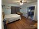 Light blue bedroom with hardwood floors, a ceiling fan, and access to the kitchen at 804 Dennis St, Troy, NC 27371