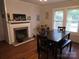 Dining room with hardwood floors, a wooden table set, and a decorative fireplace at 804 Dennis St, Troy, NC 27371