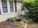 Charming home exterior with a rock-lined pond and landscaped garden at 804 Dennis St, Troy, NC 27371