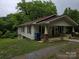 Exterior view of home featuring a covered porch with rocking chairs and well-maintained landscaping at 804 Dennis St, Troy, NC 27371