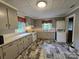 Functional kitchen with gray cabinets, tiled countertops, and included washer/dryer at 804 Dennis St, Troy, NC 27371