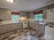 Well-lit kitchen featuring gray cabinets, tiled countertops, and washer/dryer hookups at 804 Dennis St, Troy, NC 27371