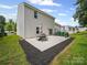 Spacious backyard features a concrete patio, complemented by lush greenery and clear skies at 8314 Paw Valley Ln, Charlotte, NC 28214