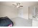 Neutral bedroom features a ceiling fan, closet, and an adjacent open bathroom doorway at 8314 Paw Valley Ln, Charlotte, NC 28214