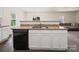 Kitchen island with granite countertops, stainless steel sink, and black dishwasher at 8314 Paw Valley Ln, Charlotte, NC 28214