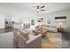 Bright, open living room leading to kitchen and dining, featuring modern decor and a ceiling fan at 8314 Paw Valley Ln, Charlotte, NC 28214