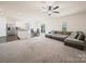 Open concept living space featuring neutral walls, plush carpet, and fan at 8314 Paw Valley Ln, Charlotte, NC 28214