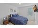 Cozy bedroom featuring a bed with a blue comforter, side tables, and natural light from the window at 9110 Buckley Ct # 154, Charlotte, NC 28269