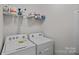 Functional laundry room with washer, dryer, and storage shelving at 9110 Buckley Ct # 154, Charlotte, NC 28269