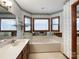 Main bathroom features a large soaking tub, wallpaper, vanity and bright lighting at 965 Hunting Ave, Lincolnton, NC 28092