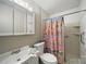Functional bathroom with a standard toilet, vanity, medicine cabinet, shower, and patterned curtain at 9818 Starwood Dr, Charlotte, NC 28215